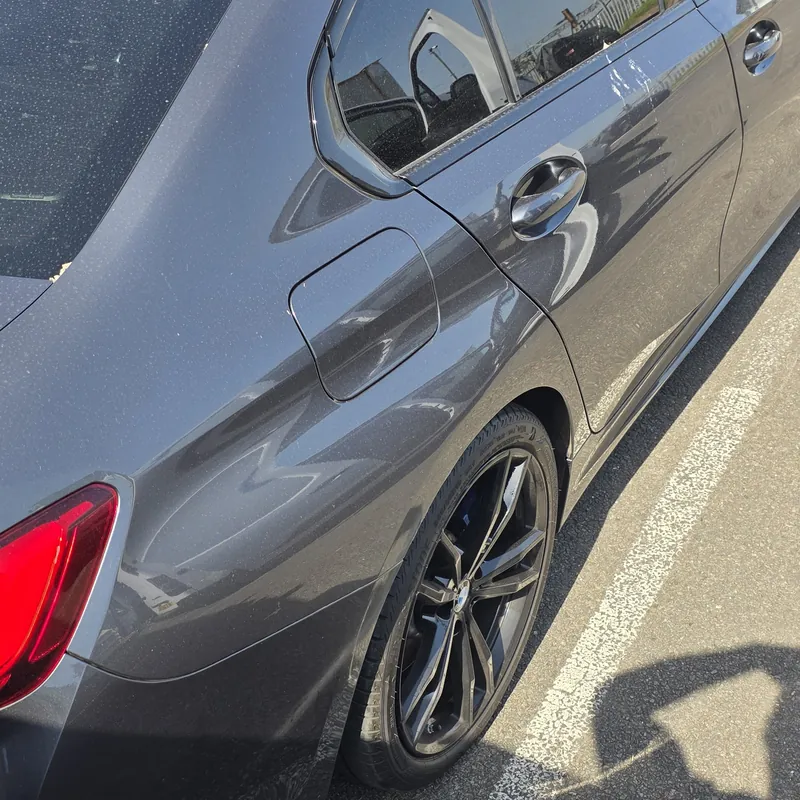 Grey BMW 3 Series under a film of dust before an exterior wash in NW London