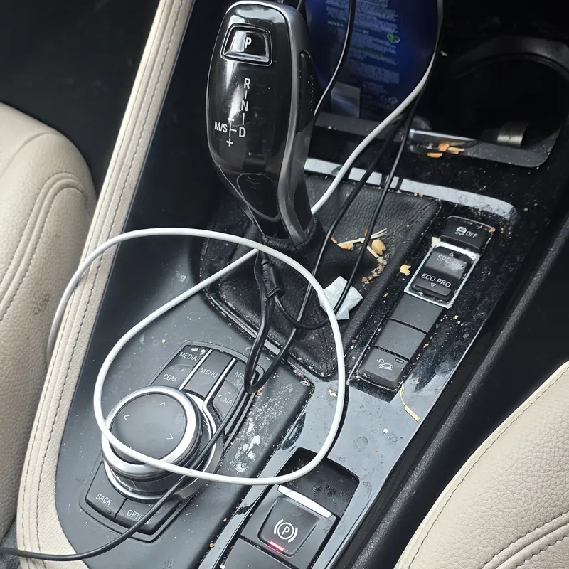 BMW X1 centre console with crumbs and grime before an interior deep clean