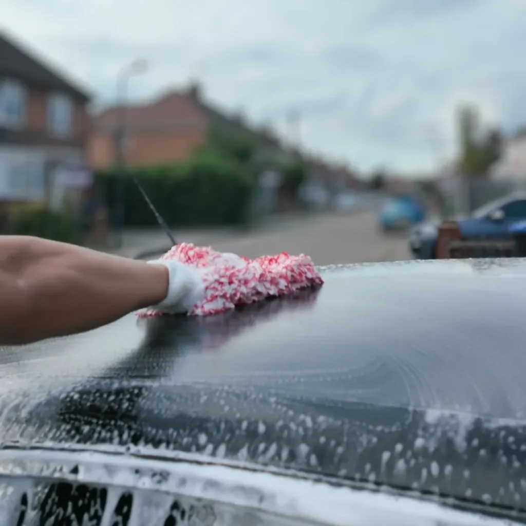 PureShine Detailing founder hand washing a car in Wembley