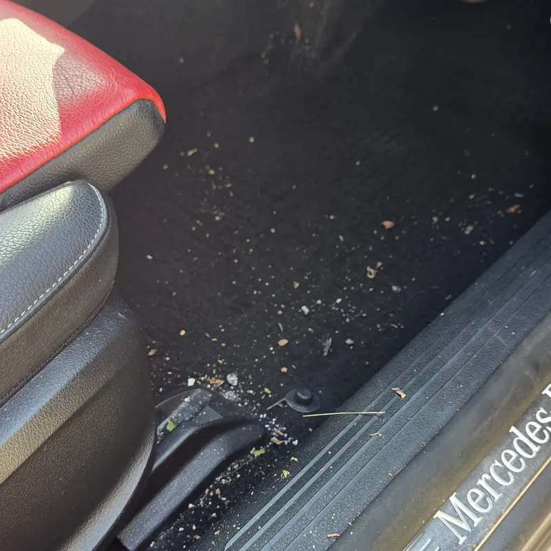 Mercedes footwell with dirt and debris before an interior valet