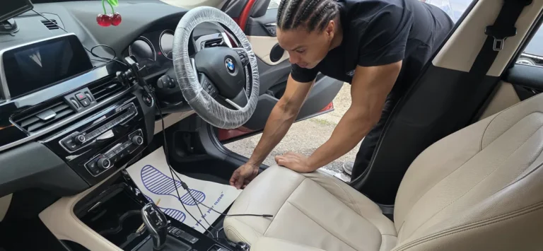 PureShine detailer laying protective disposable mats inside a BMW during a mobile valet