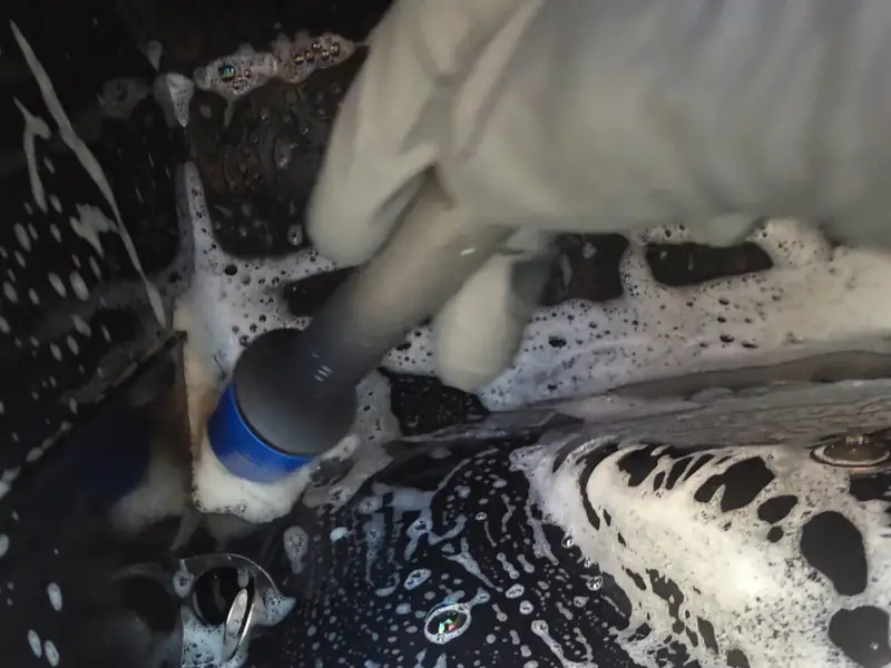 Snow foam and detail brush being used safely on car paint in Ealing