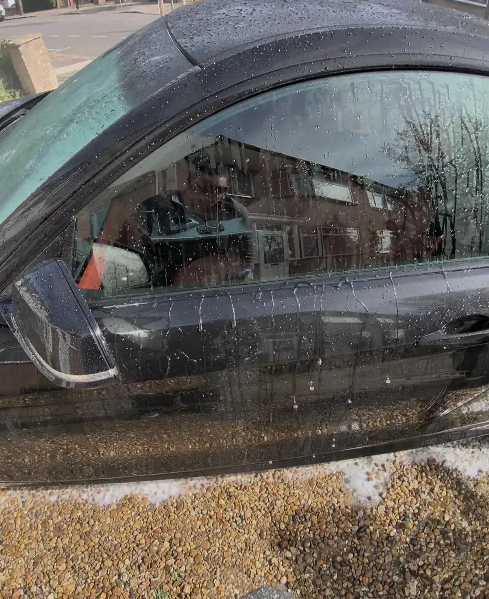 Water beading on black car paint after a ceramic coating in NW London